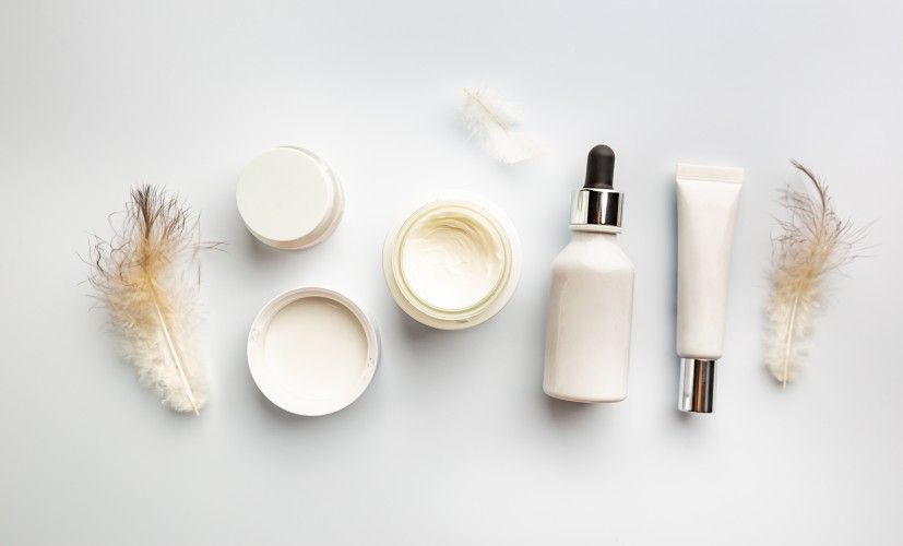 skin-care-products-and-feathers-on-white-backgroun