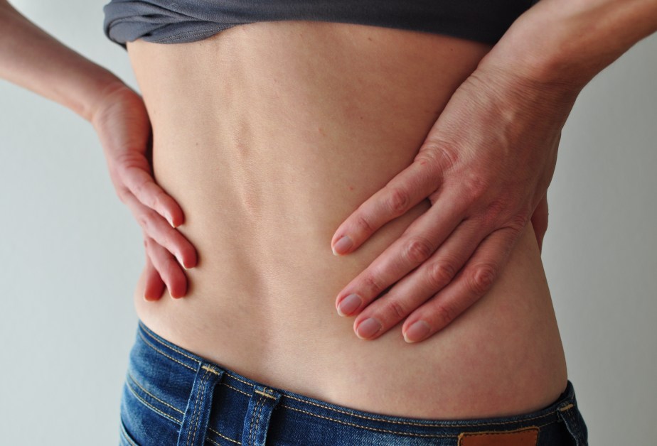 woman-with-liftet-up-t-shirt-holding-her-hips